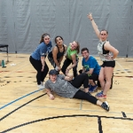 Six staff members posing on the GVSU basketball court